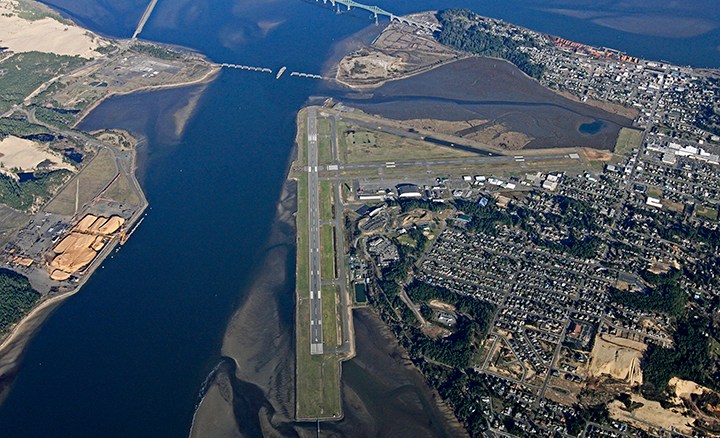 Aerial view of the Port of Coos Bay, with housing developments and an airplane strip near the Coos Bay bridge.